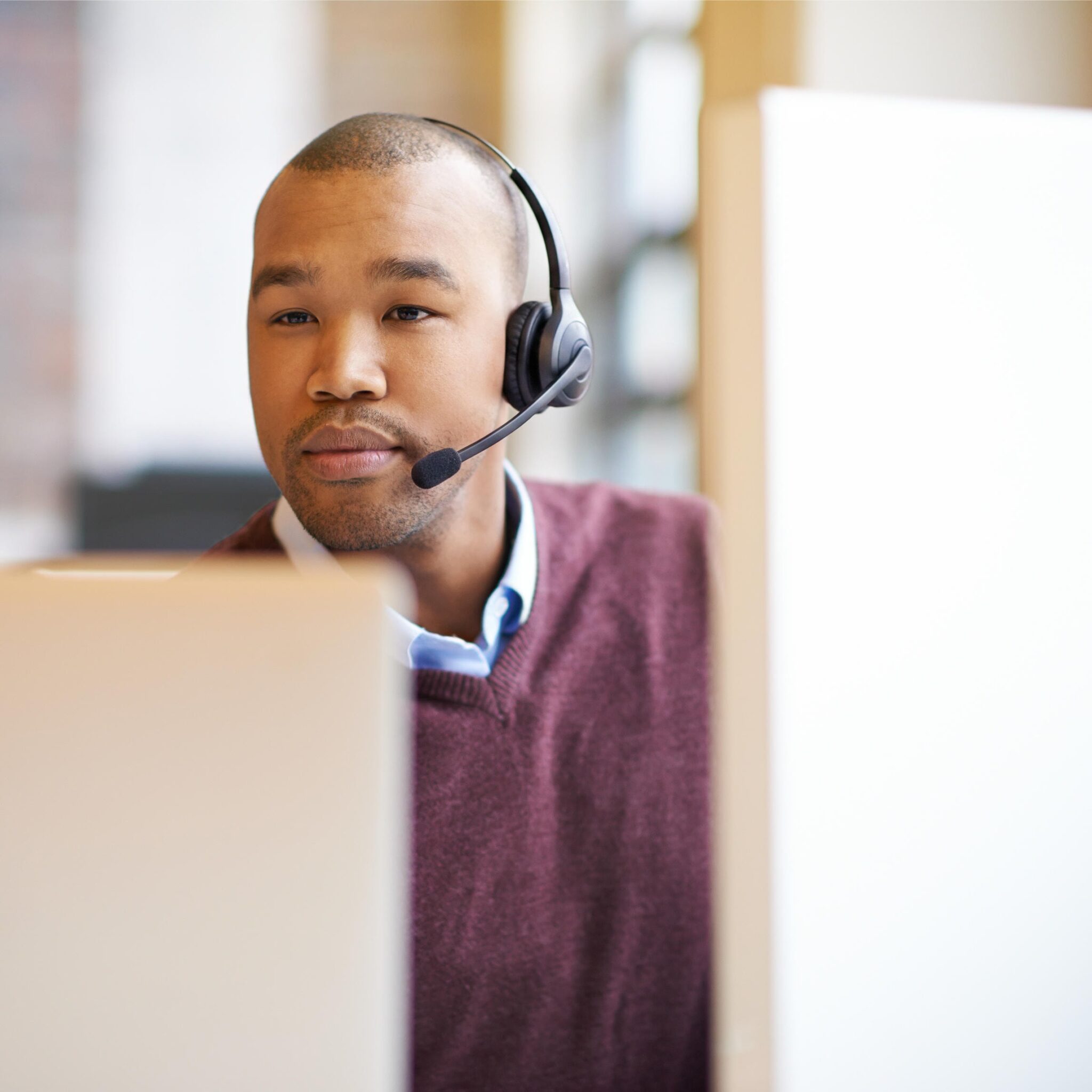 A customer service professional representative sits at their workstation with headset on